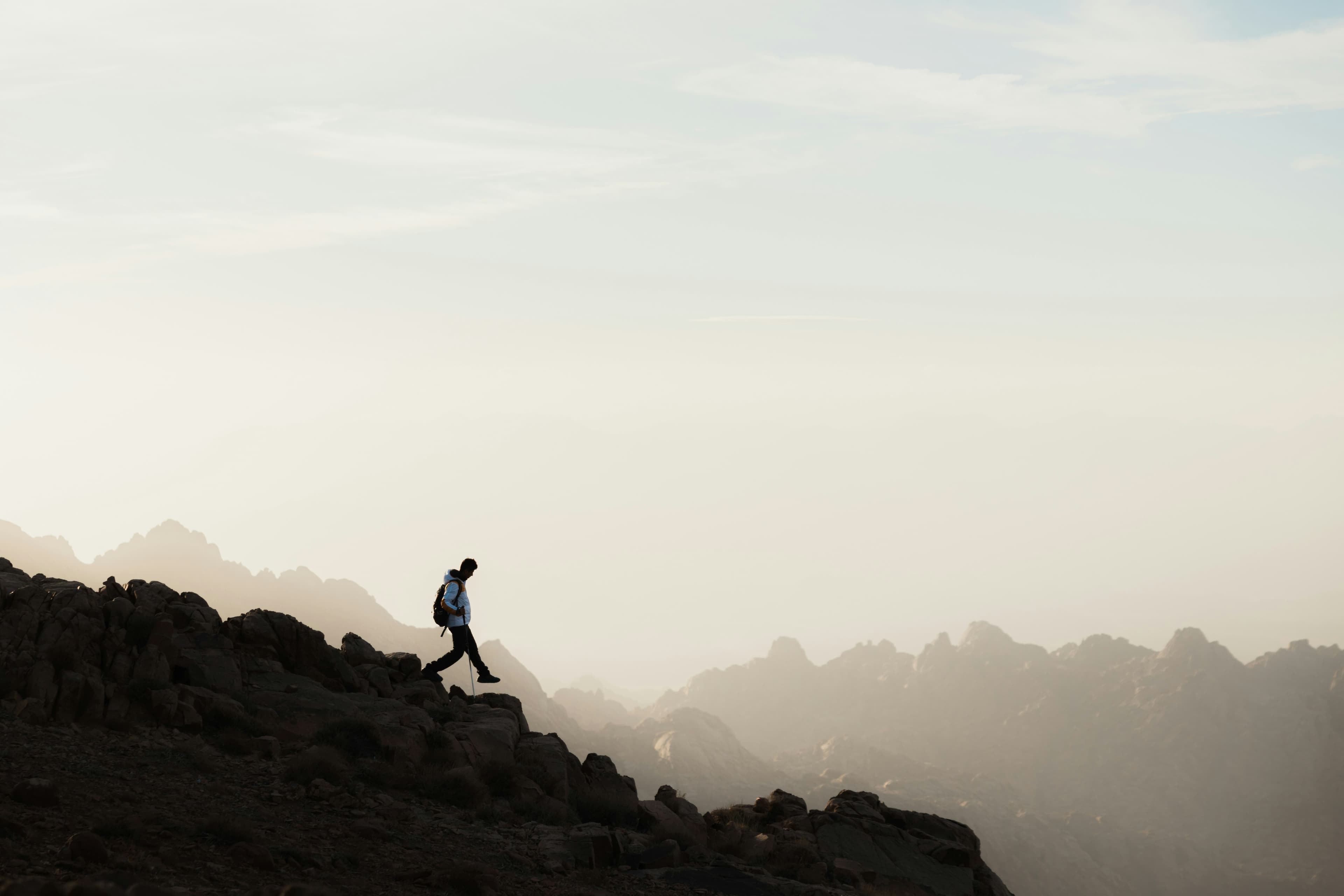 a woman standing in front of a vast mountaintop