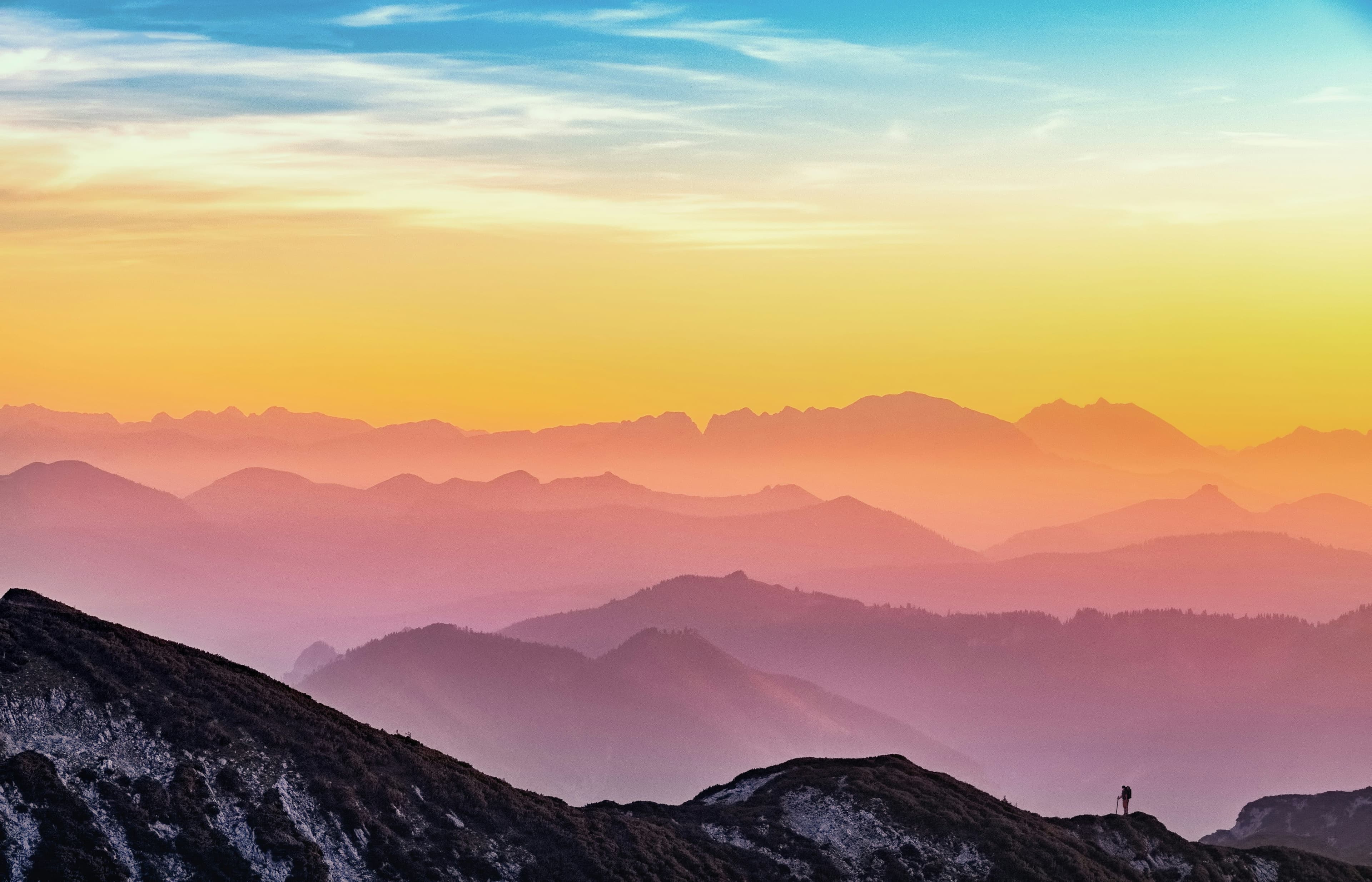 a woman standing in front of a vast mountaintop
