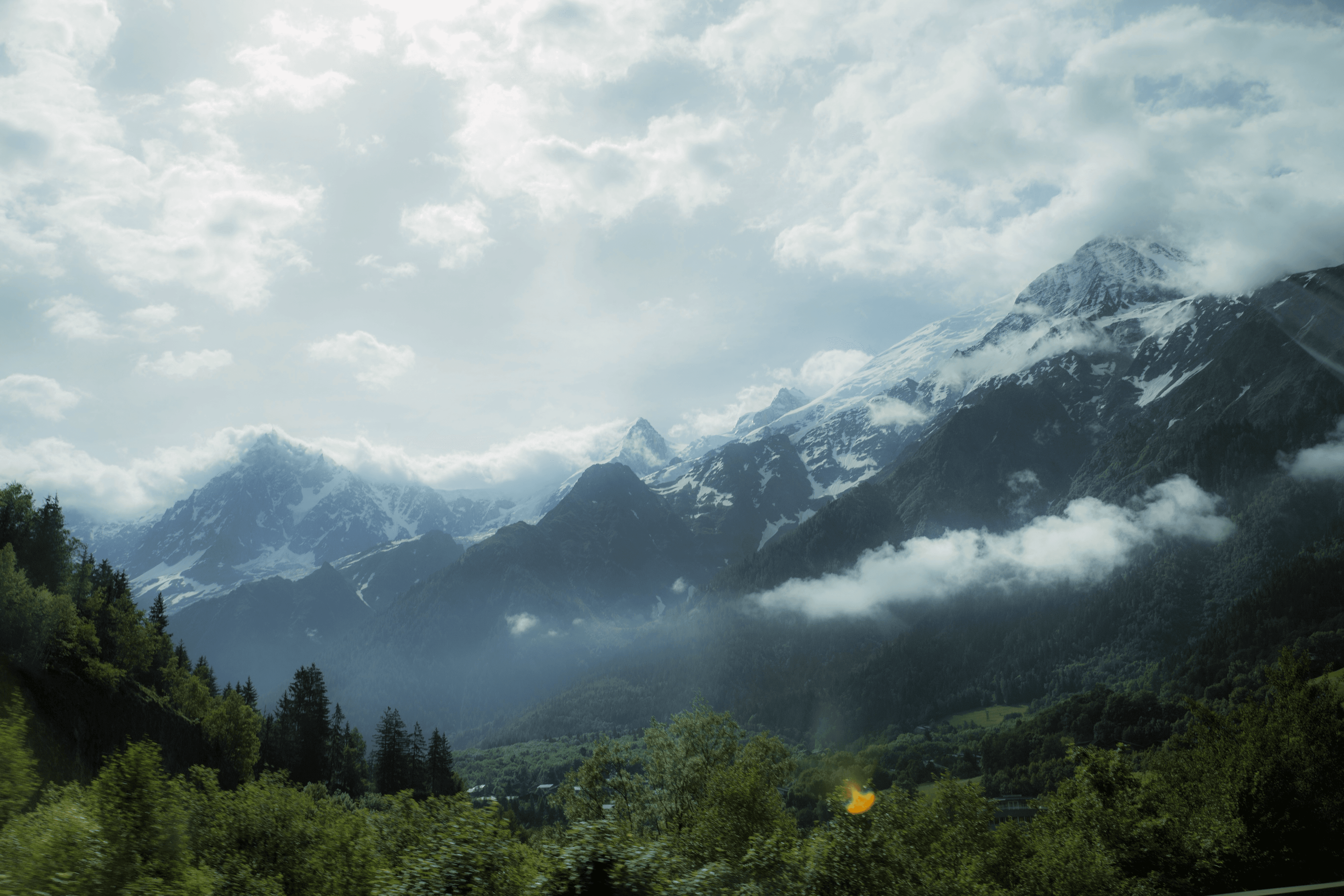 a woman standing in front of a vast mountaintop